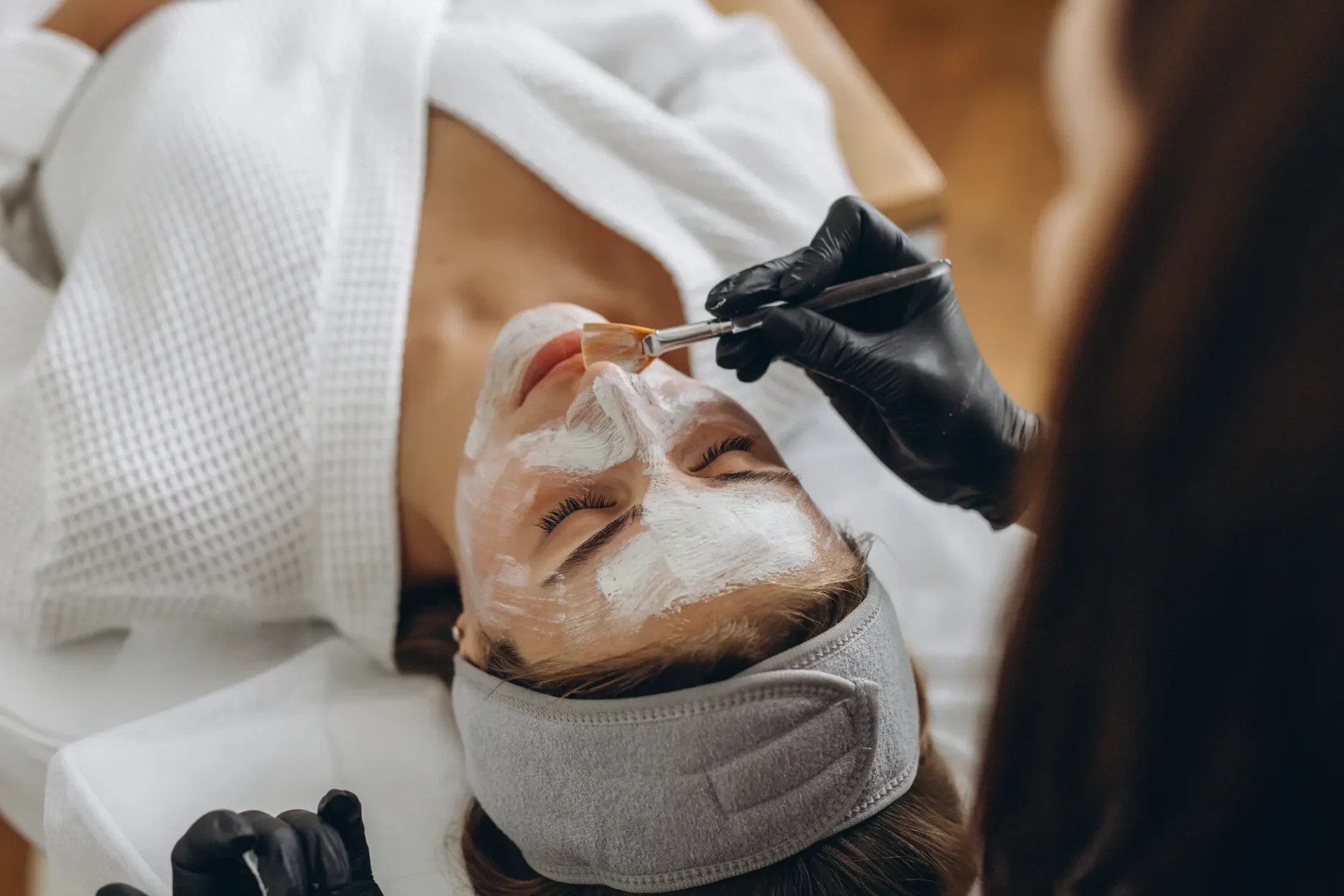 Facial treatment with mask and brush application.